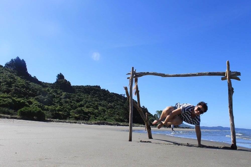 estudiar inglés una chica saltando en la arena de una playa